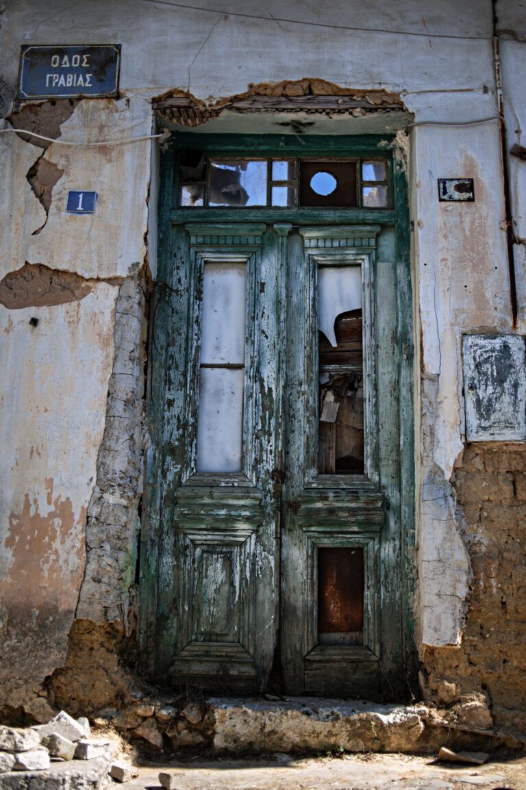An old green door of an abandoned building.