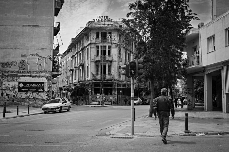 An abandoned hotel building in downtown Athens with the hotel sign perched on the top. Taken in black and white