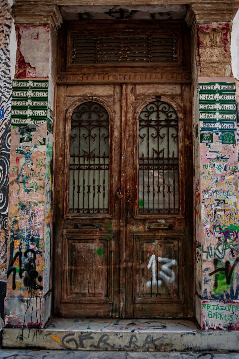 An old wooden door of an abandoned house with the number 13 spray painted on to it