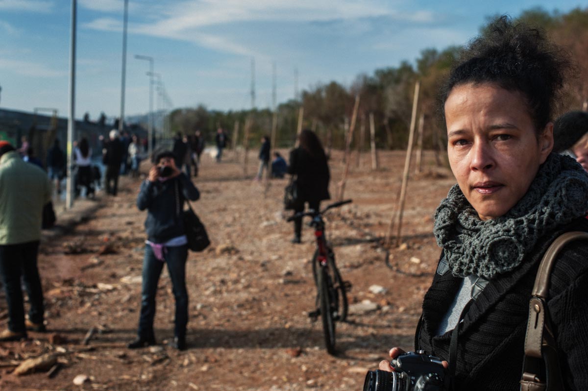 A photo of me with my camera in the foreground and people moving around in the background