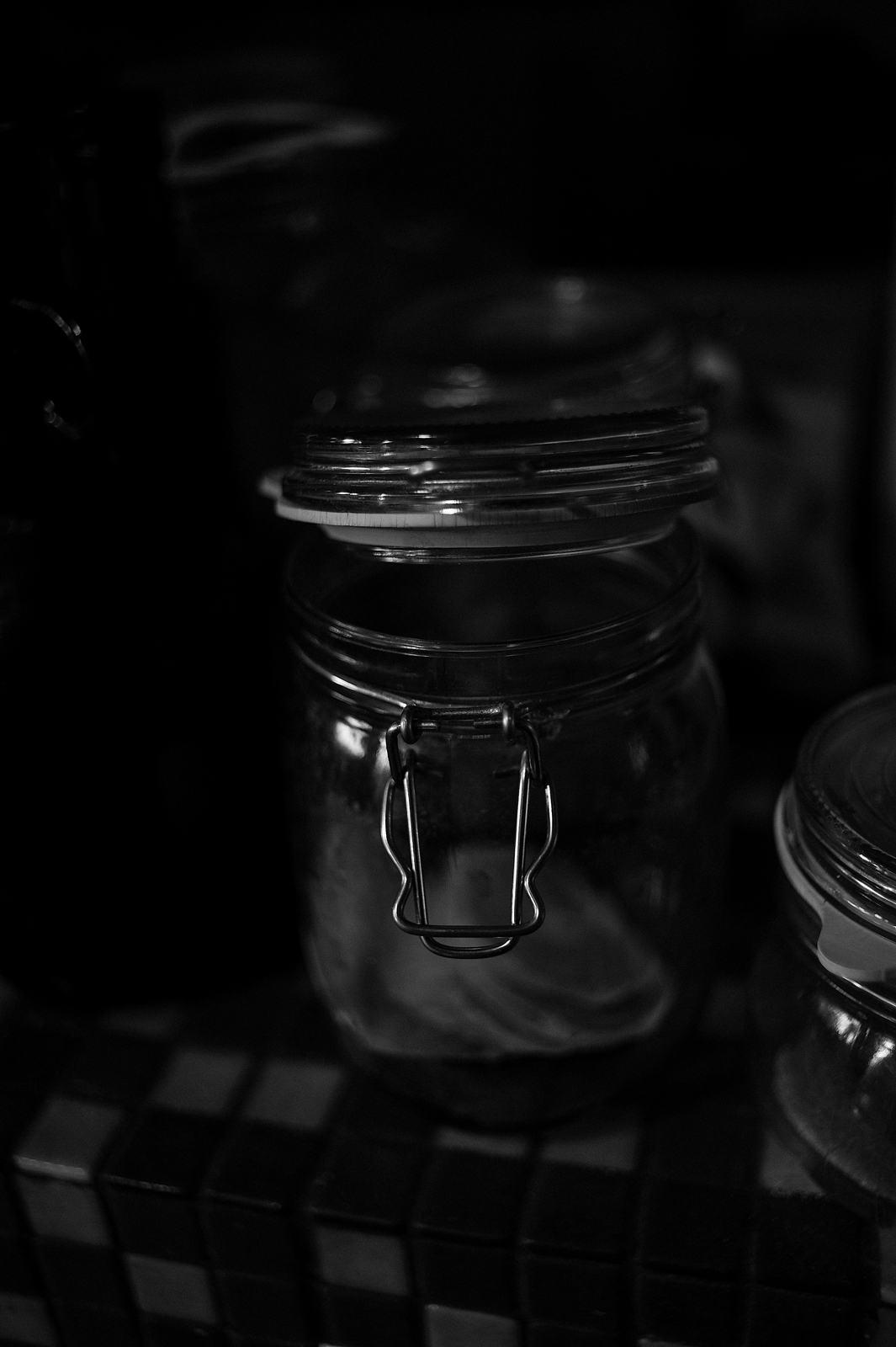 Closeup black and white photograph of a detail of glass jar