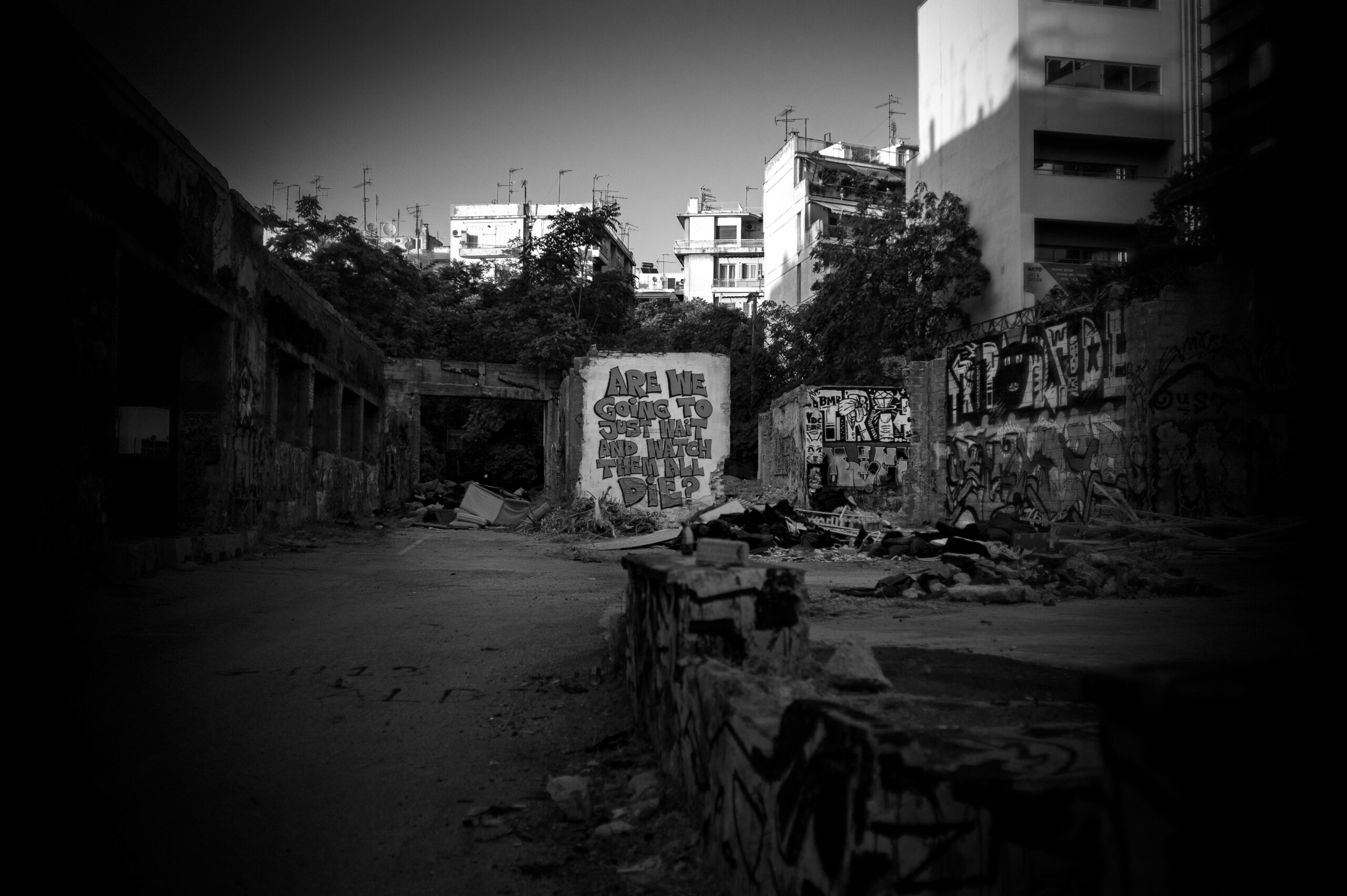 A black and white photograph of an inner city wasteland with graffiti.