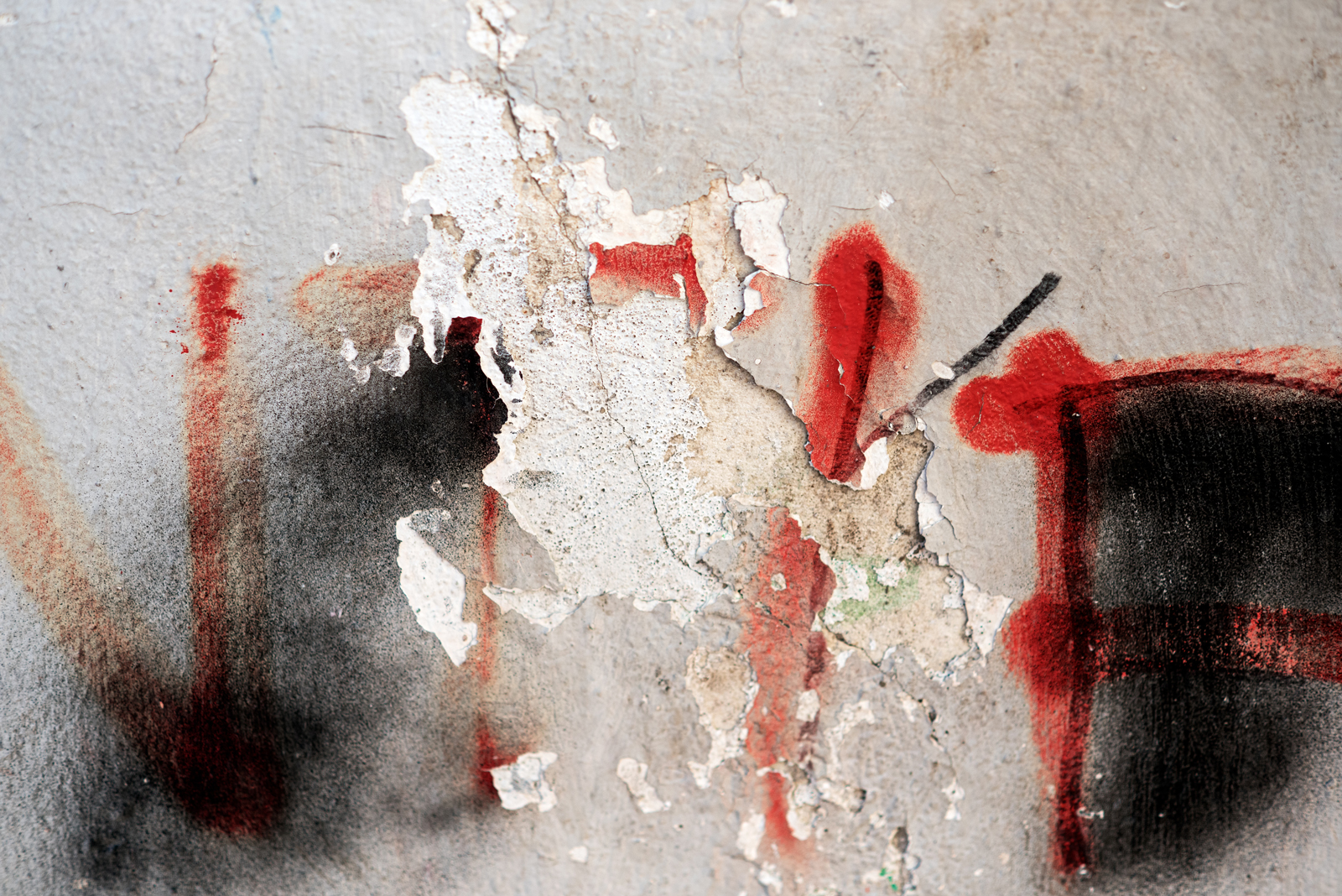A wall with red grafitti shown closeup