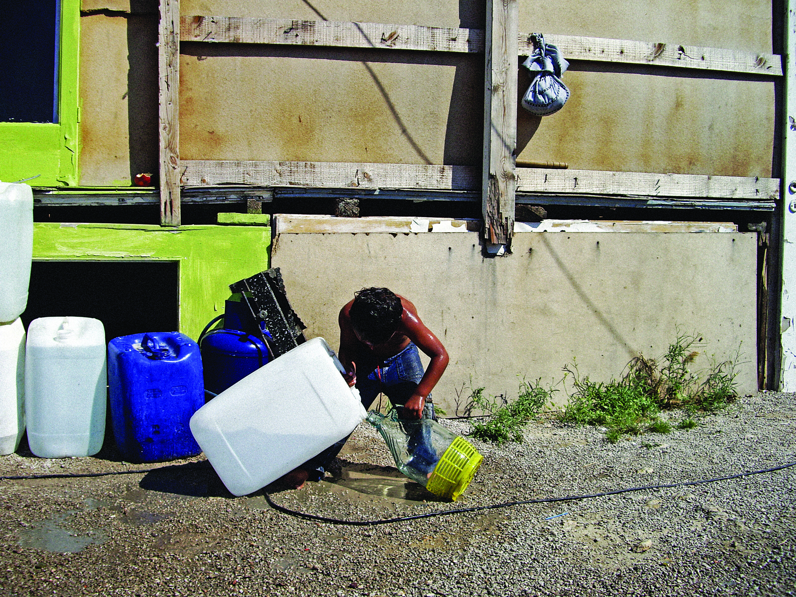 Boy with water at a Roma camp in Athens.