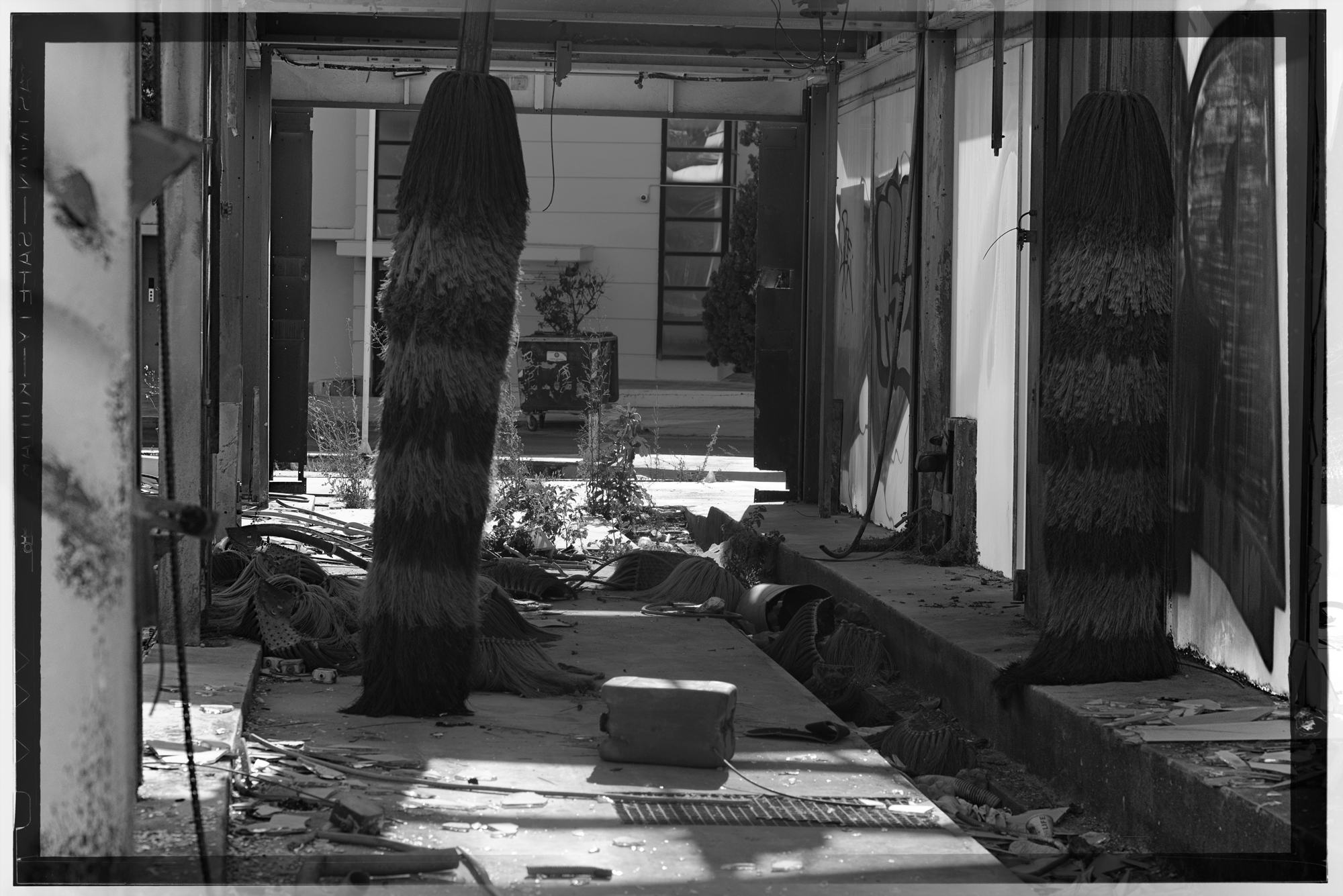 A photograph of an abandoned car wash in black and white